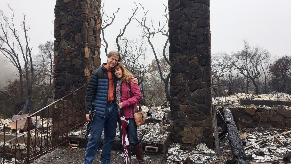 2018 photo of Birgit and Jeff Sengstack in front of the ruins of their home that burned down.