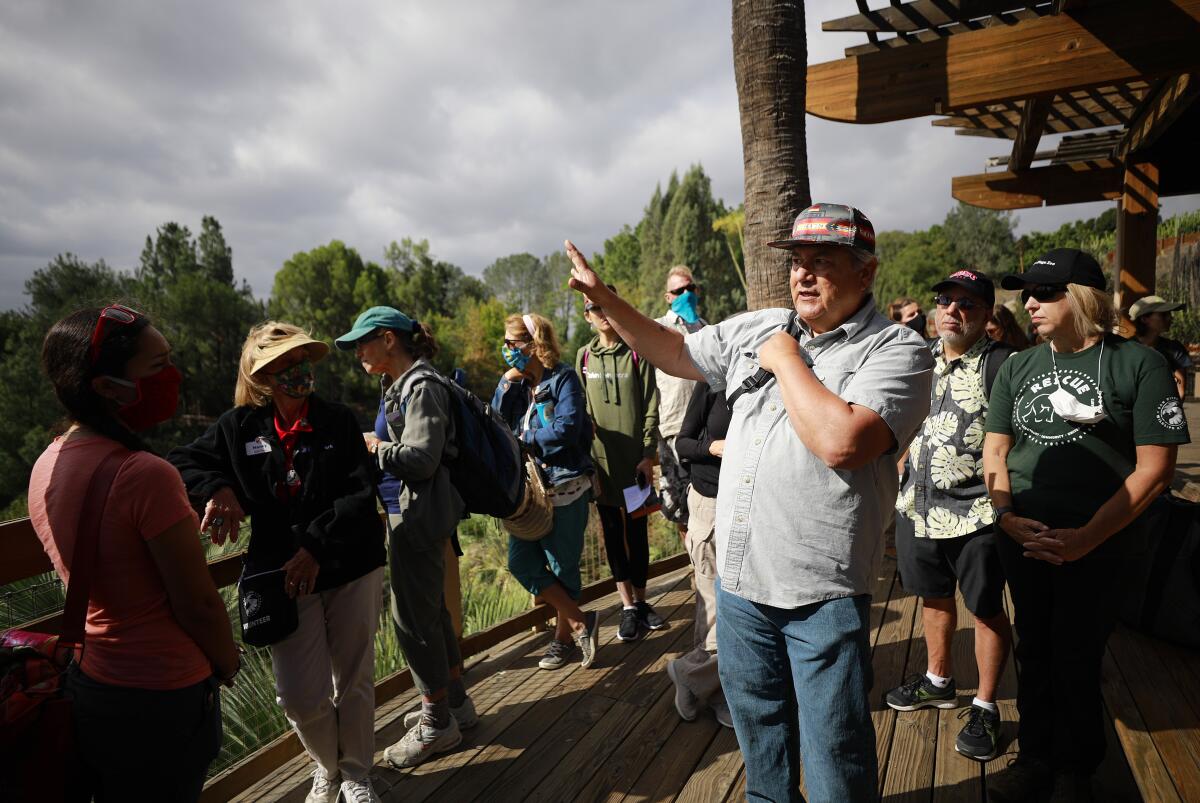 a man speaks to a group during an outdoor hike