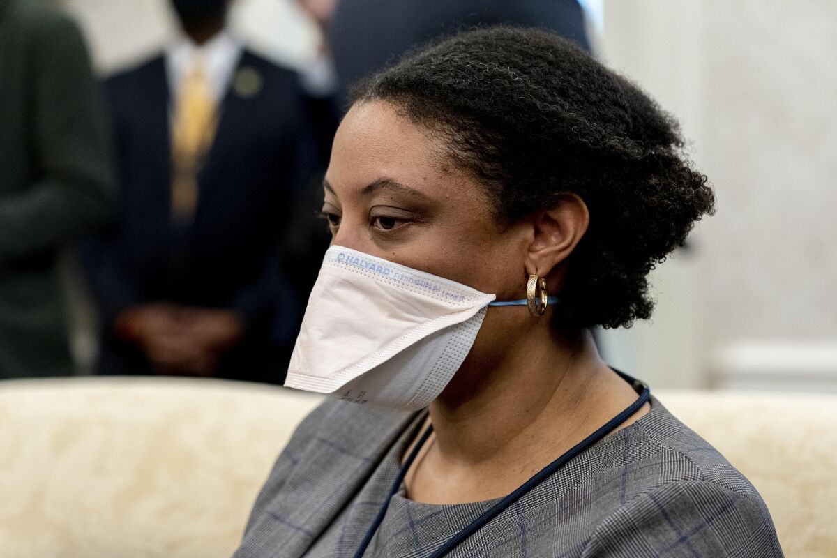 Shalanda Young wears a mask as she sits in the Oval Office. 