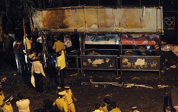 Indian police officers look for clues at the site of an explosion in the Dadar district in the center of Mumbai.