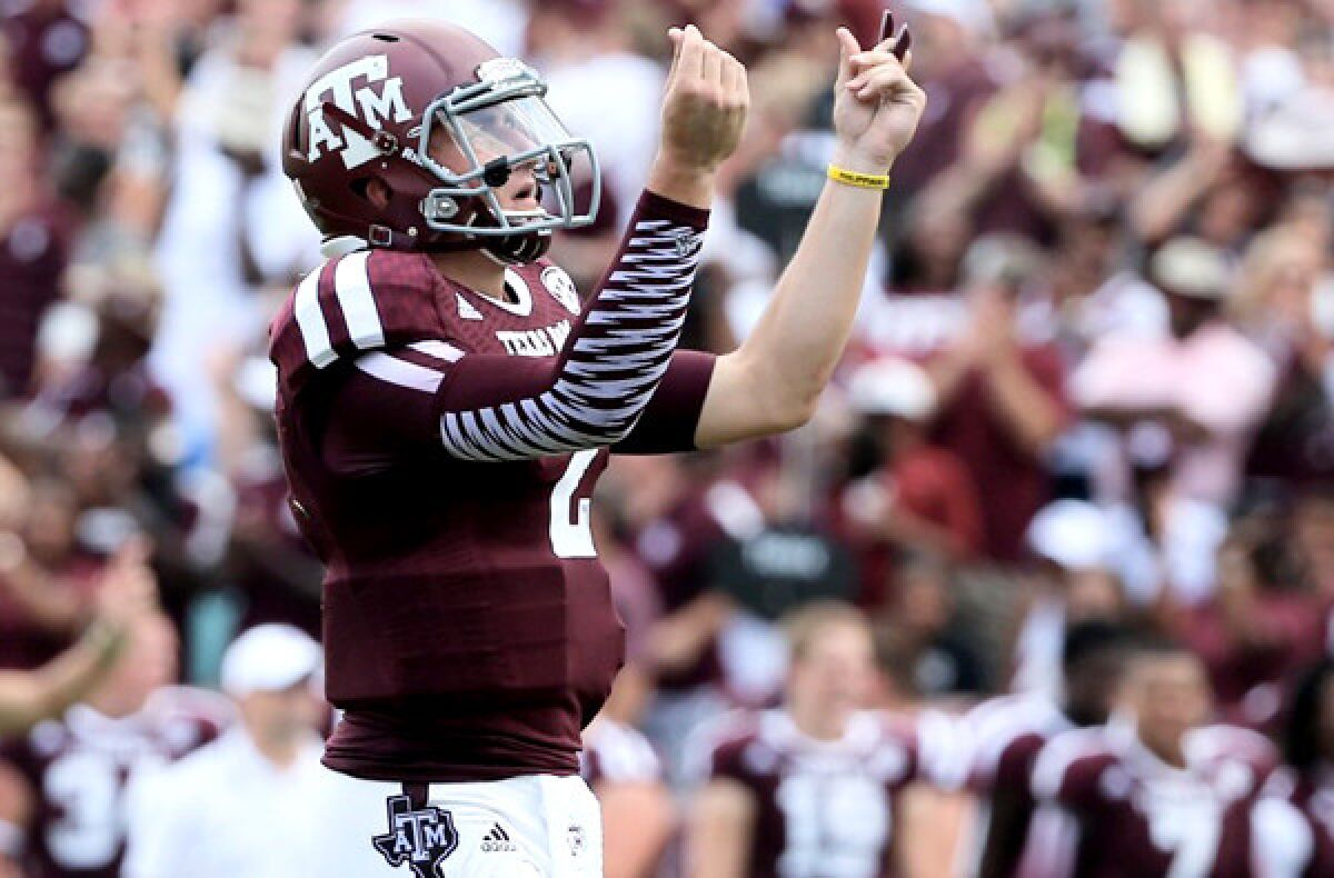 Texas A&M quarterback Johnny Manziel flashes a 'cash' sign after a touchdown against Rice in the third quarter Saturday.