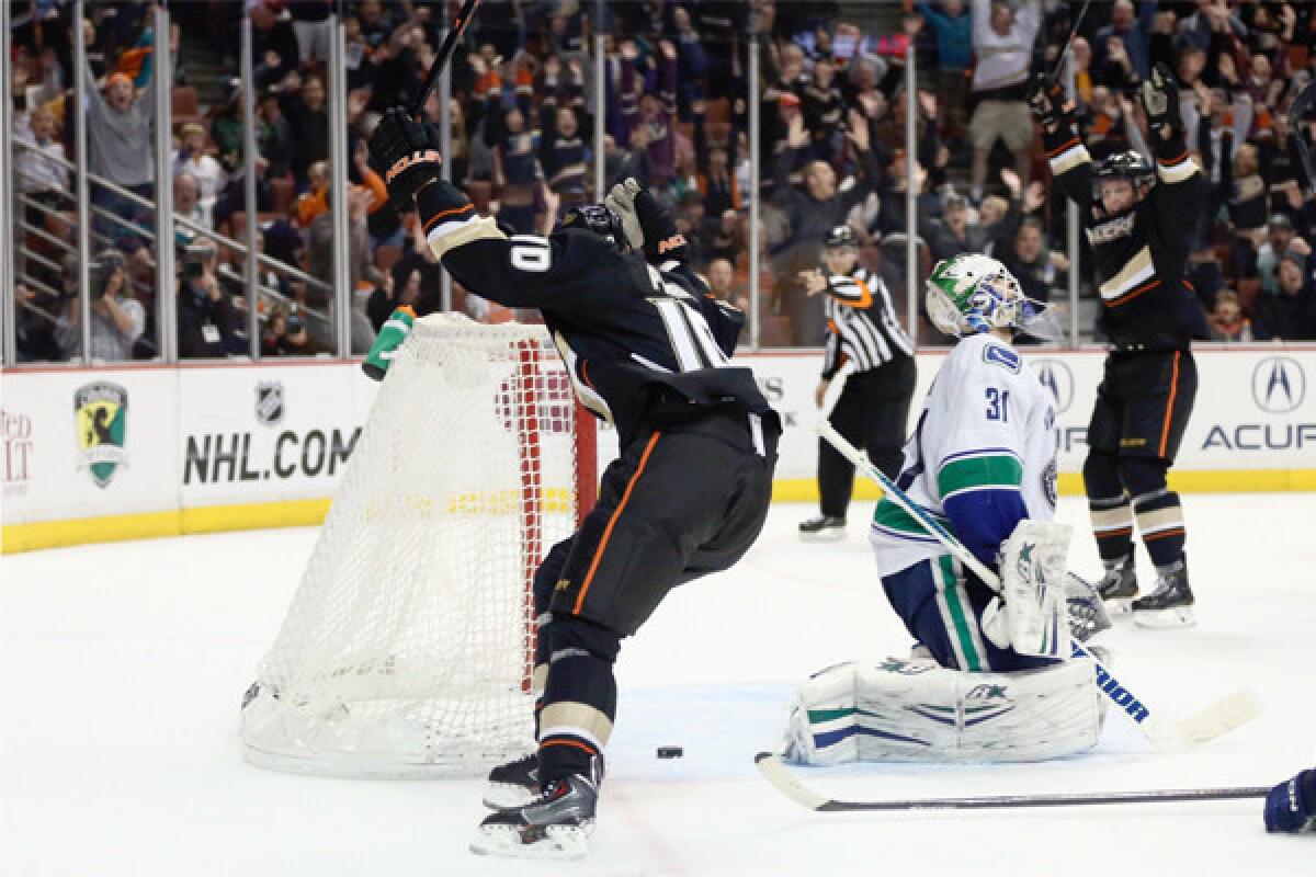 The Ducks' Corey Perry celebrates after scoring the game-winning goal with about a second remaining in overtime, as Vancouver goaltender Eddie Lack reacts Sunday at the Honda Center.