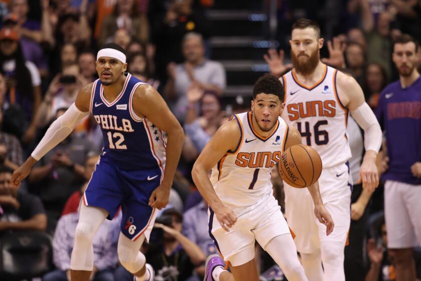 Suns guard Devin Booker starts a fastbreak ahead of teammate Aron Baynes and 76ers forward Tobias Harris during a 114-109 win on Nov. 4, 2019, in Phoenix.