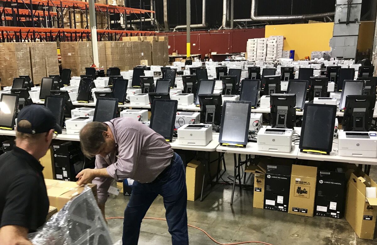FILE - This Feb. 14, 2020, file photos shows voting equipment including touchscreen tablet, printer and scanner in a metro Atlanta warehouse, to be tested before shipped to Georgia counties. (AP Photo/Jeff Martin, File)