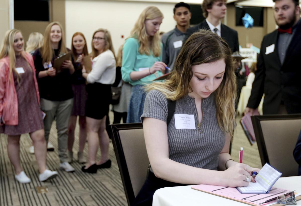FILE - In this April 5, 2017, file photo, Memorial High School senior Taylor Wicks figures which life insurance plan to purchase during the Eau Claire Area Chamber of Commerce's Real Life Academy at the Lismore Hotel in Eau Claire, Wis. A rise in freelancing, coupled with an increasing interest in flexible employment from millennial and Gen Z workers, could signal a change in how Americans build and calculate life insurance plans. (Marisa Wojcik/The Eau Claire Leader-Telegram via AP, File)