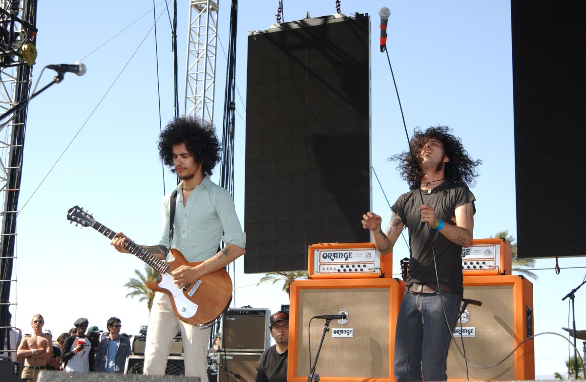 Two members of a rock band perform onstage