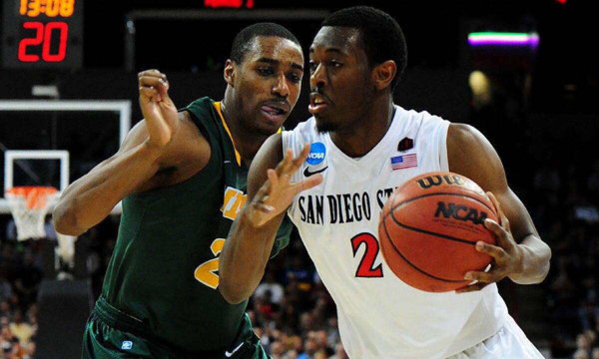 San Diego State's Xavier Thames, right, drives past North Dakota State's Kory Brown during the second half of the Aztecs' 63-44 win in the third round of the NCAA tournament Saturday.