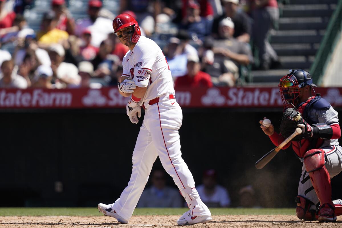 Angels designated hitter Mike Trout, left, tosses his bat after drawing a walk.