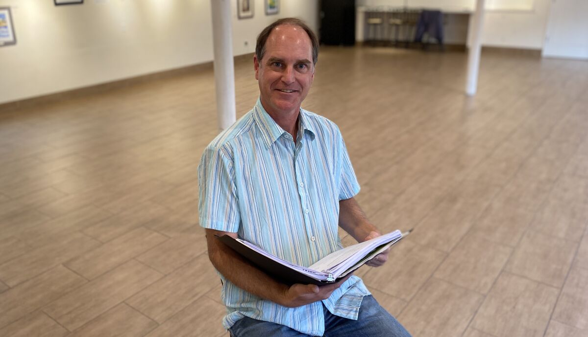 John Tessmer poses in the Great Room at La Jolla Community Center, where he is about to direct and act in a program of a dozen short plays about climate change.