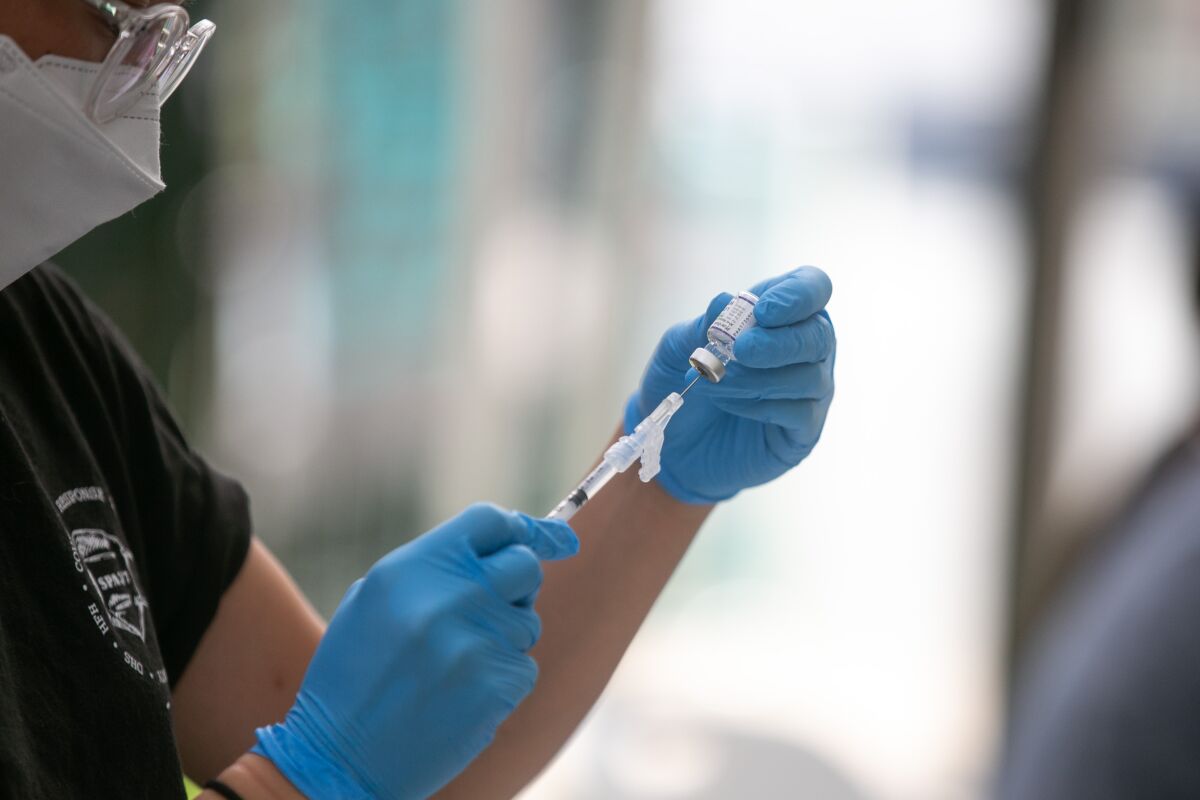 A health worker prepares a syringe