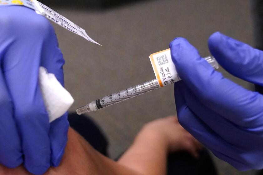 An eight-year-old child receives a second dose of the Pfizer COVID-19 vaccine at Northwest Community Church in Chicago, Saturday, Dec. 11, 2021. Pfizer is adding an extra dose of its COVID-19 vaccine for babies and preschoolers enrolled in a study of the shots. Pfizer and its partner BioNTech announced, Friday, Dec. 17, they were adding a third dose to the study after a preliminary analysis found 2- to 4-year-olds didn't have as strong an immune response as expected. (AP Photo/Nam Y. Huh)