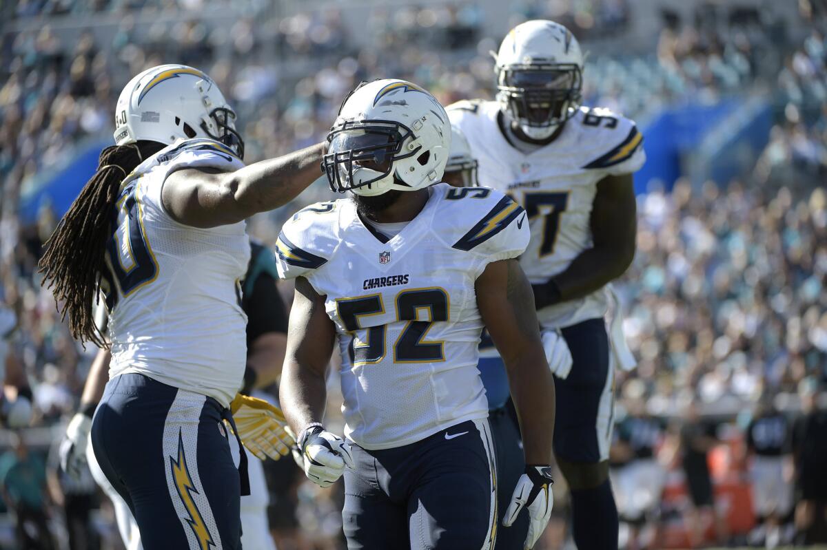 Chargers linebacker Denzel Perryman (52) is congratulated by defensive end Ricardo Mathews (90) and fellow linebacker Jeremiah Attaochu (97) after a tackle during a game on Nov. 29.