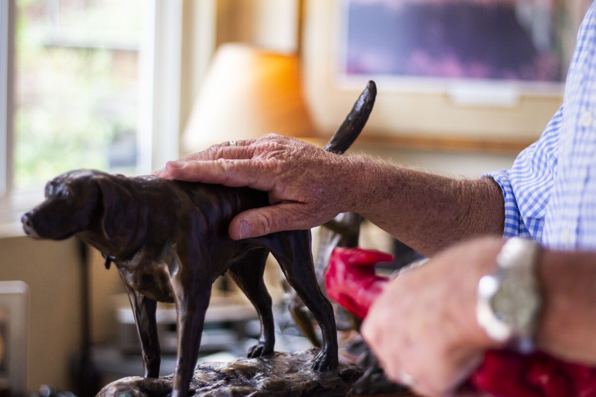 James Kermott talks about one of his bronze dog sculptures at his home studio in Encinitas.
