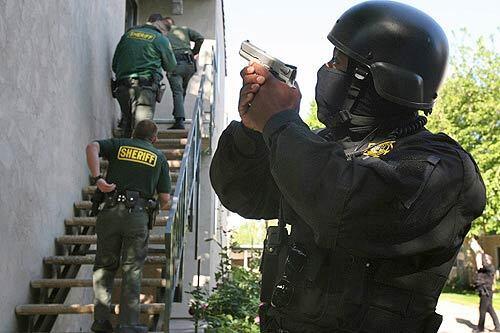 Los Angeles County sheriff's deputies approach an apartment in Lancaster. Officials in the Antelope Valley are conducting one of the most aggressive campaigns in the nation to stamp out unauthorized or illegal behavior in federally subsidized housing.