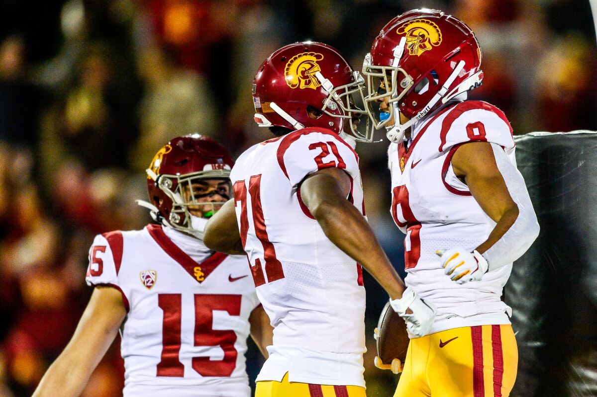 USC's Amon-ra St. Brown (8) is congratulated by teammate Tyler Vaughns (21) and Drake London (15) after scoring a first-quarter touchdown.