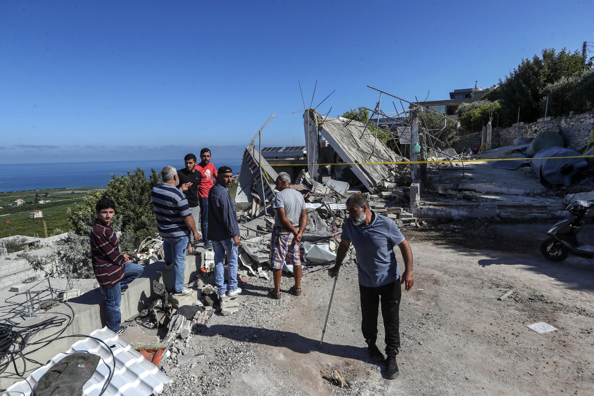 黎巴嫩男子正在检查被毁房屋的废墟。