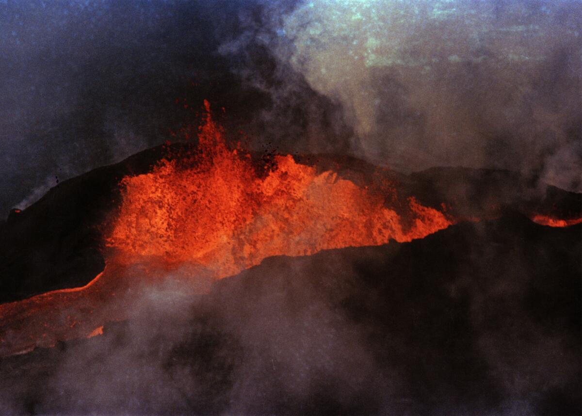 Orange lava erupts and flows from Mauna Loa amid smoke.