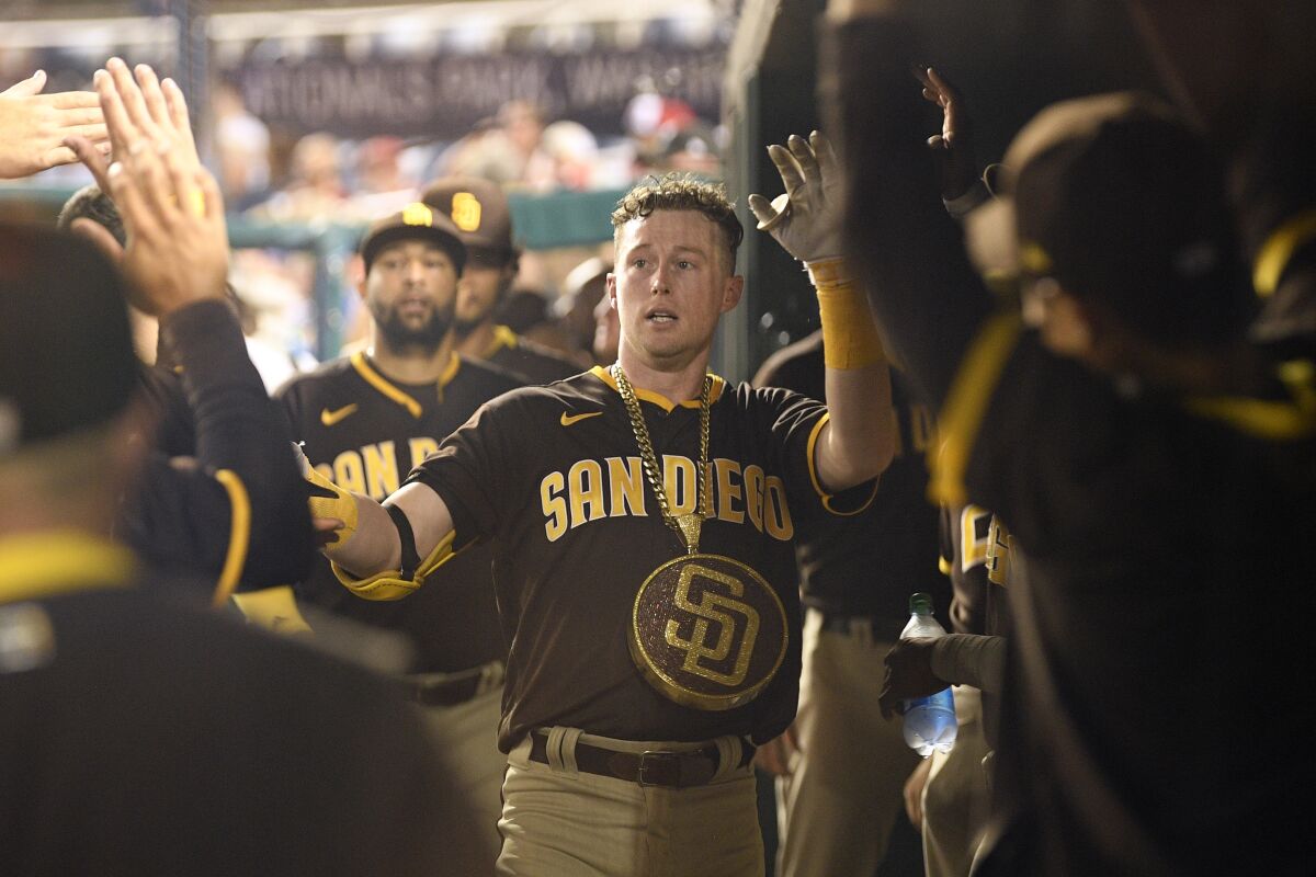 San Diego Padres' Jake Cronenworth celebrates in the dugout after his home run during the fifth inning of a baseball game against the Washington Nationals, Friday, July 16, 2021, in Washington. (AP Photo/Nick Wass)