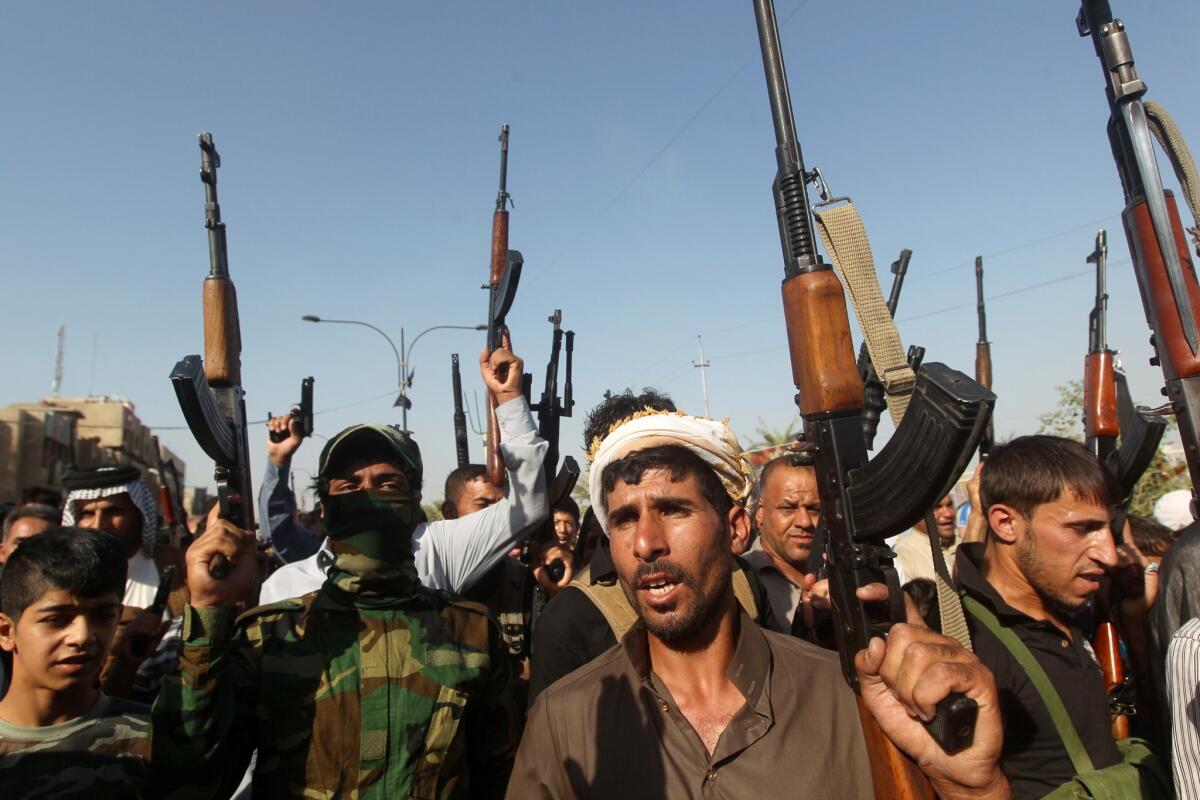 Iraqi tribesmen hold up their weapons as they gather in Baghdad to show their readiness to join Iraqi security forces in the fight against Islamist militants who have taken over several Iraqi cities.