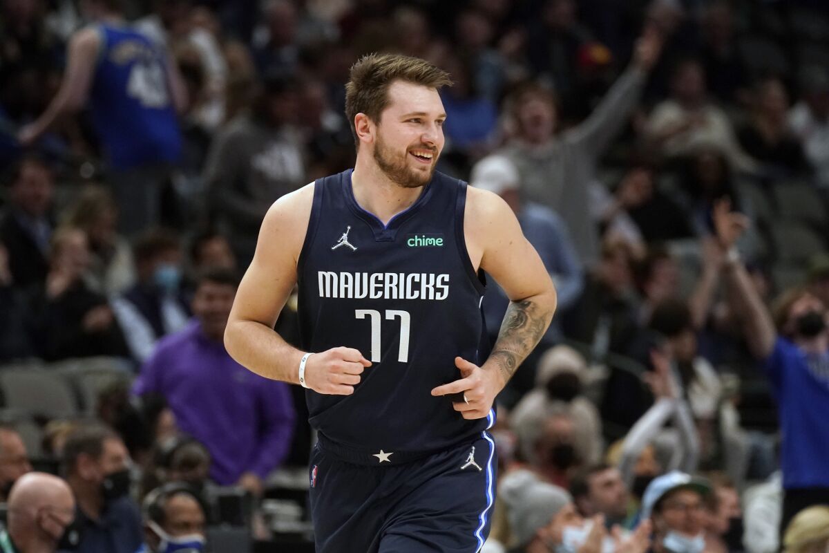 Dallas Mavericks guard Luka Doncic (77) smiles after hitting a 3-pointer during the first quarter of the team's NBA basketball game against the Los Angeles Clippers in Dallas, Thursday, Feb. 10, 2022. (AP Photo/LM Otero)