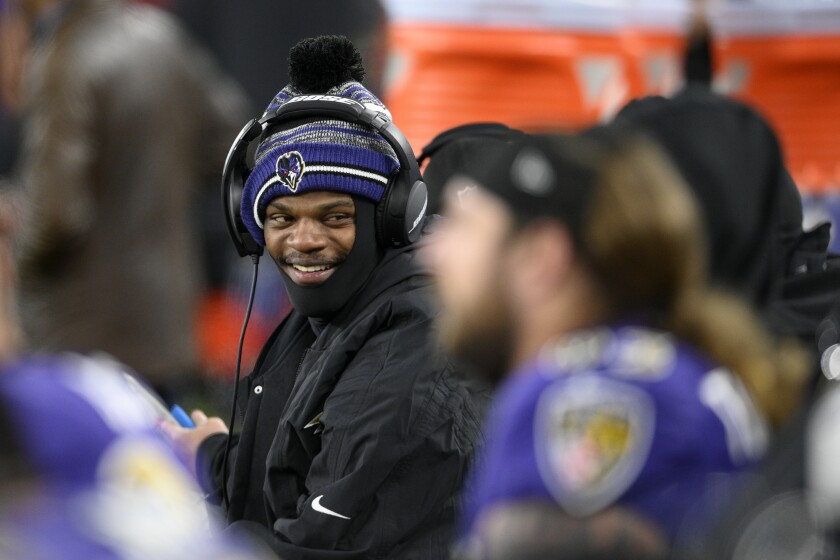 Baltimore Ravens quarterback Lamar Jackson sits on the Ravens sideline in the first half of an NFL football game against the Green Bay Packers, Sunday, Dec. 19, 2021, in Baltimore. (AP Photo/Nick Wass)
