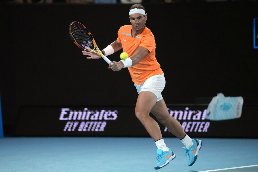 Rafael Nadal of Spain plays a backhand return to Mackenzie McDonald of the U.S., during their second round match at the Australian Open tennis championship in Melbourne, Australia, Wednesday, Jan. 18, 2023. (AP Photo/Dita Alangkara)