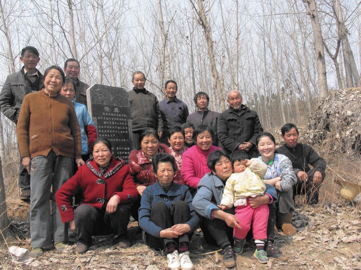 Zhang Mengqi, 28, second from right, with villagers in Diaoyutai, Hubei province, near a memorial that she helped build to commemorate local victims of the Great Famine.