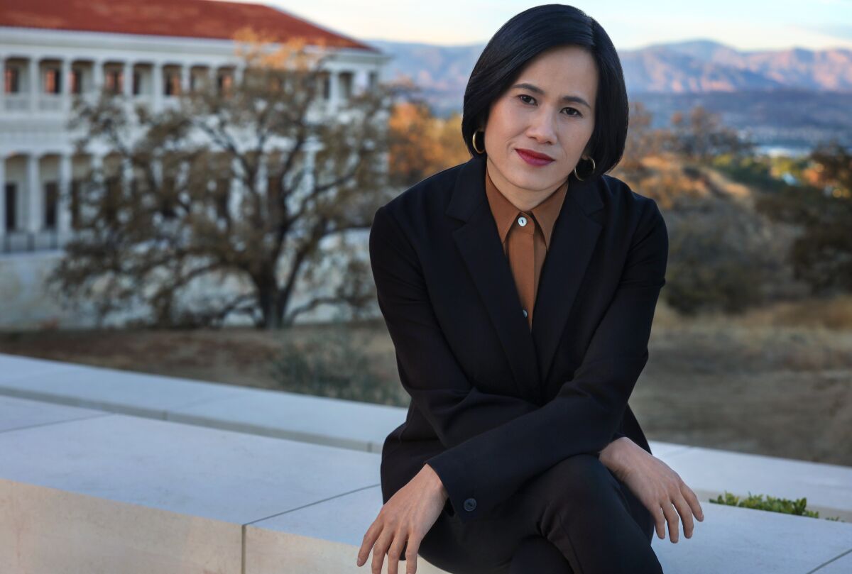 May Hong HaDuong sits on a stone wall.