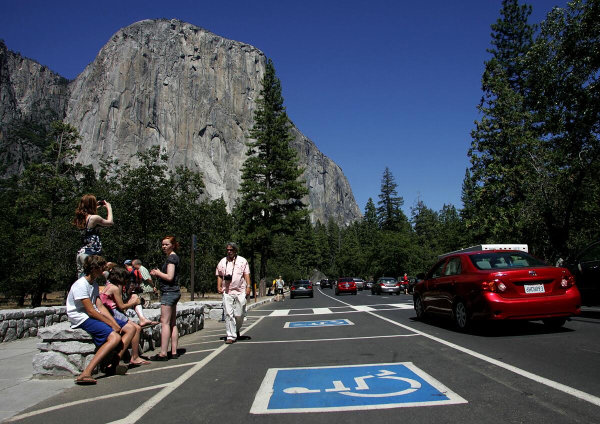 Tourists gather in a congested area of Southside Drive to view and take photos of El Capitan in Yosemite National Park in California. On busy days, more than 8,000 cars pass through Yosemite Valley.