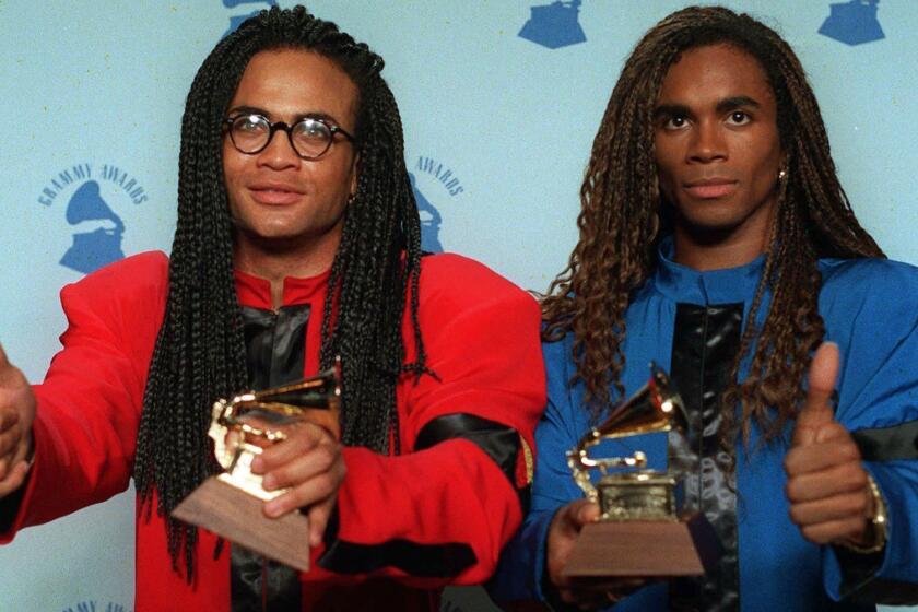 FILE - In this Feb. 21, 1990 file photo, Rob Pilatus, left, and Fab Morvan of Milli Vanilli give the thumbs-up as they display their Grammys after being presented with the best new artist award in Los Angeles. The Grammys asked the duo to return the award after it was learned that Morvan and Pilatus didn't sing on the duo's 1989 U.S. debut, "Girl You Know It's True." (AP Photo/Douglas C. Pizac, file)