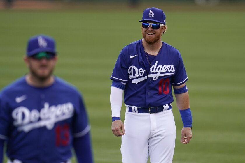 Los Angeles Dodgers' Justin Turner (10) and Max Muncy warm up prior to a spring training baseball game.