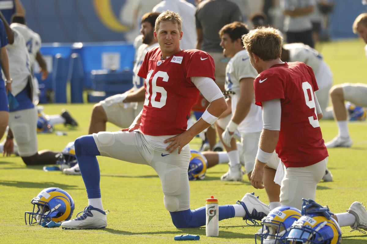 Rams quarterback Jared Goff talks with quarterback John Wolford while stretching before a team practice session.