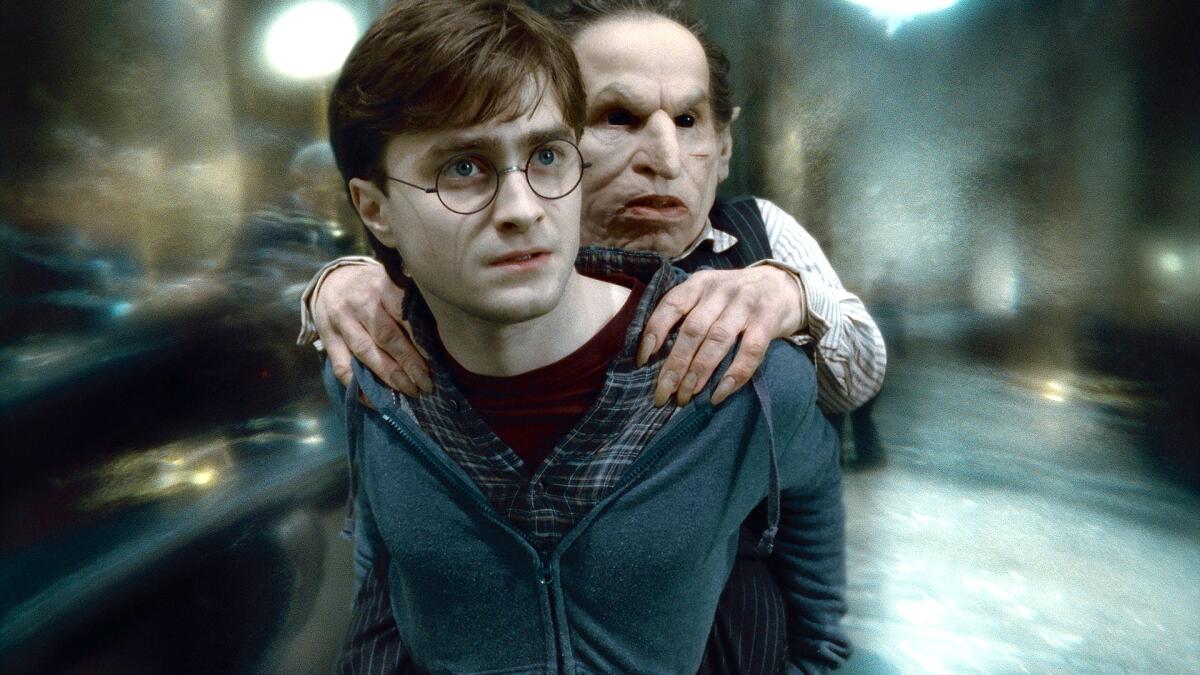 Daniel Radcliffe as Harry Potter, giving a goblin a piggyback ride. 