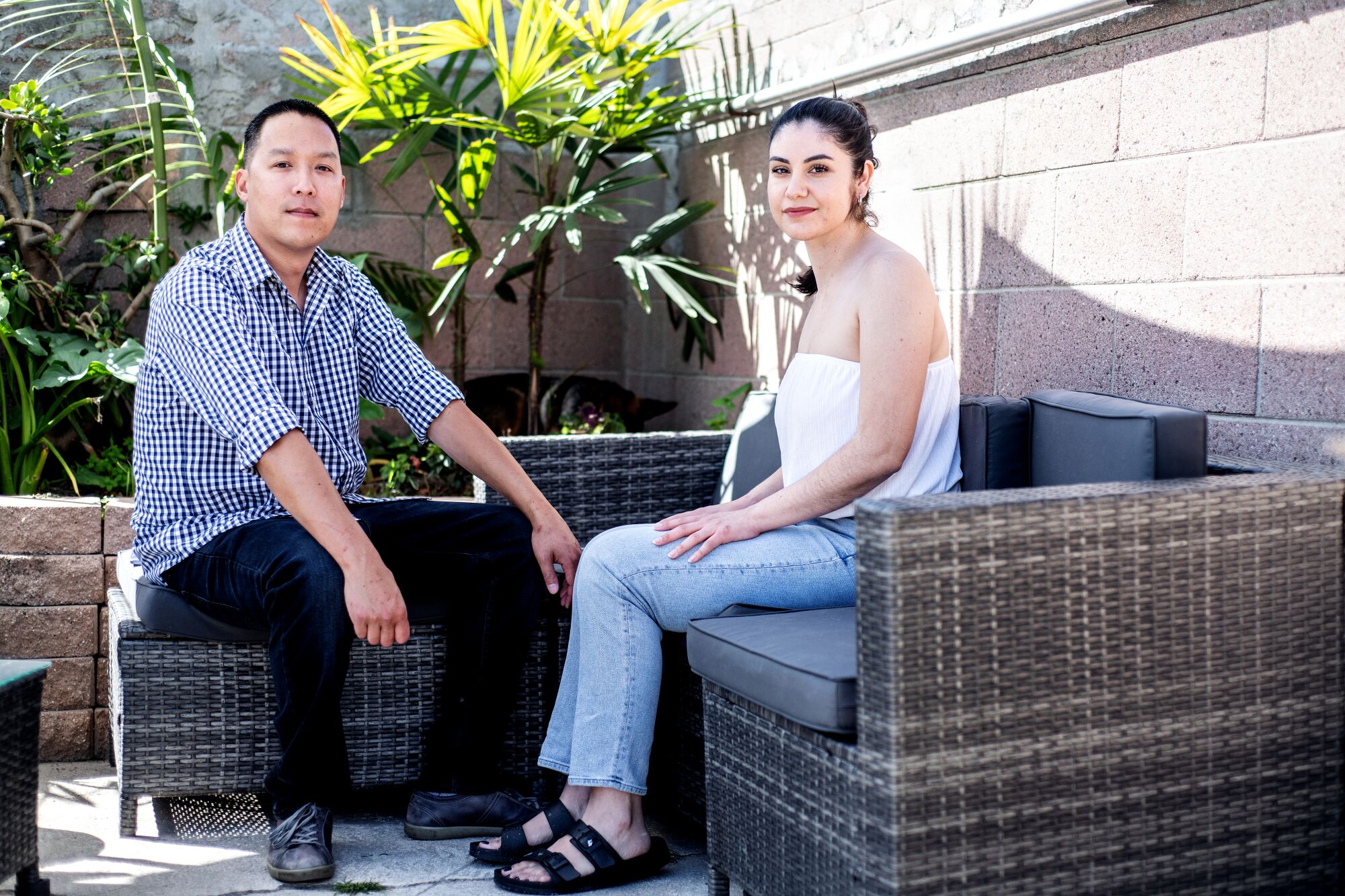 A couple sit in their backyard.