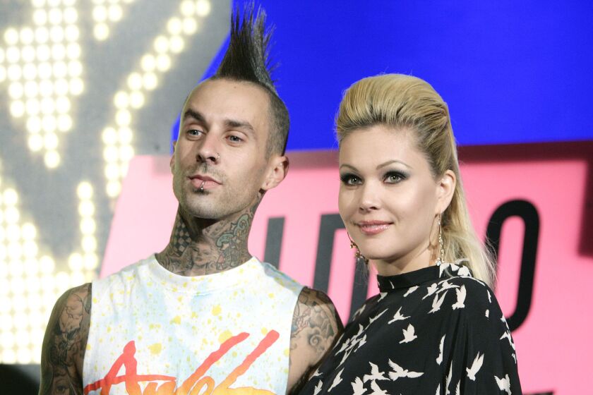A man with a mohawk and a blond woman smile