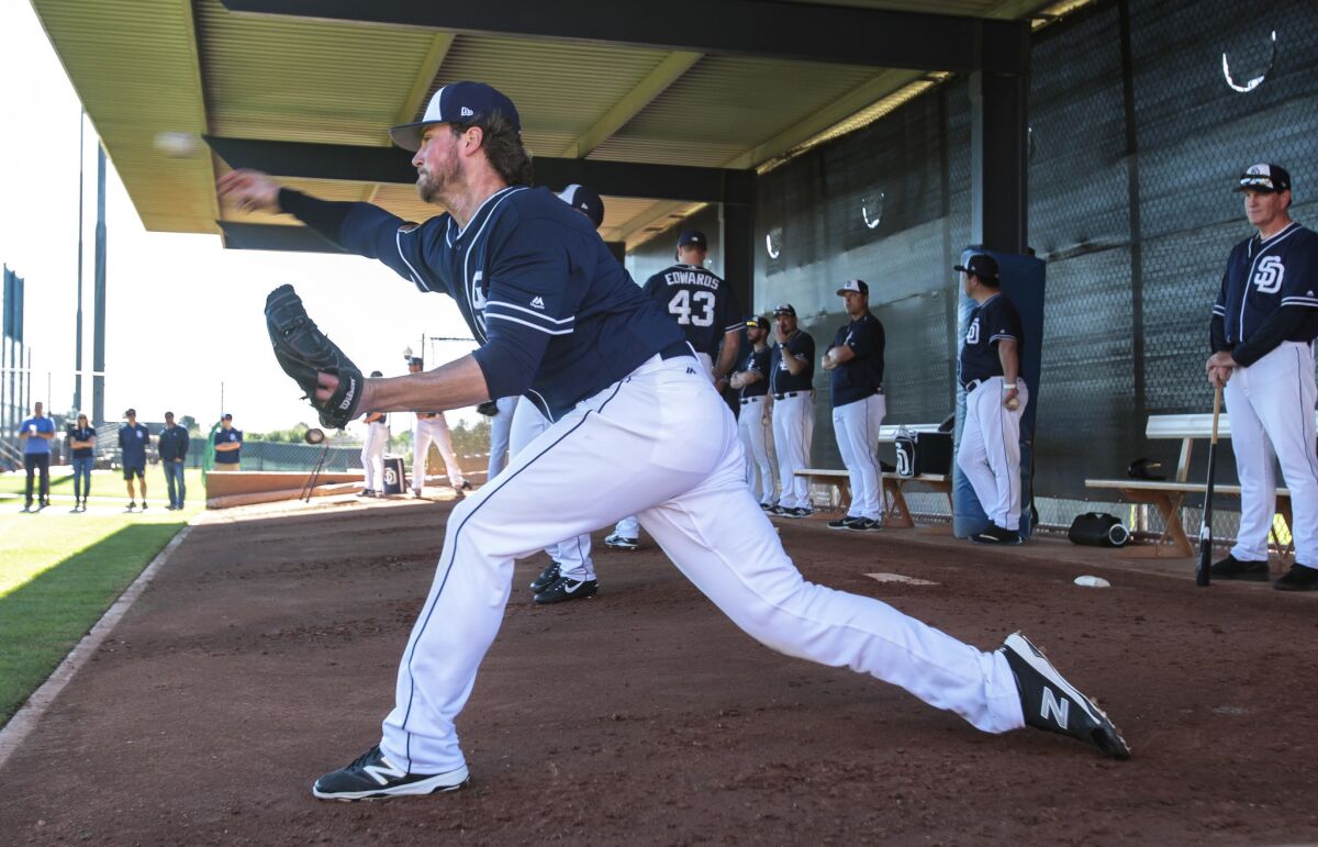 Padres pitcher Carter Capps throws in the bullpen as pitching coach Darren Balsley, far right, watches during spring training at the Peoria Sports Complex in Peoria, Arizona, on Wednesday.