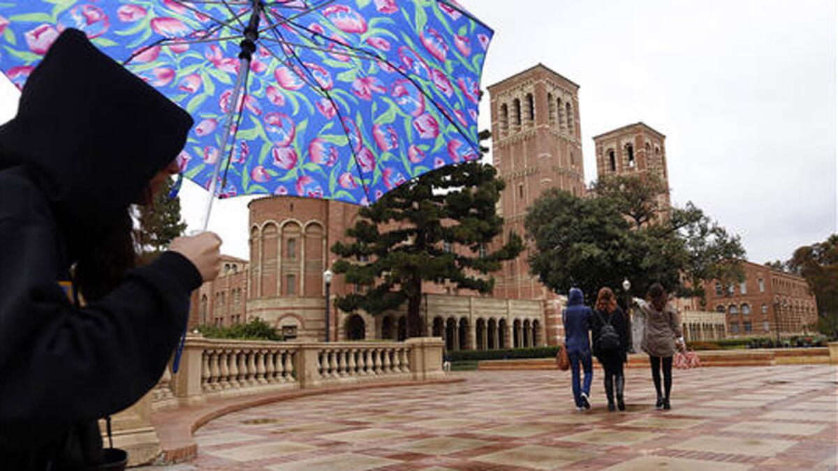 Students walk in the rain last month near Royce Hall on the UCLA campus.