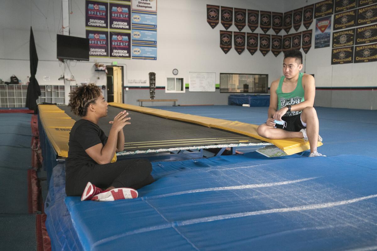 two people talking in a gymnastics gym