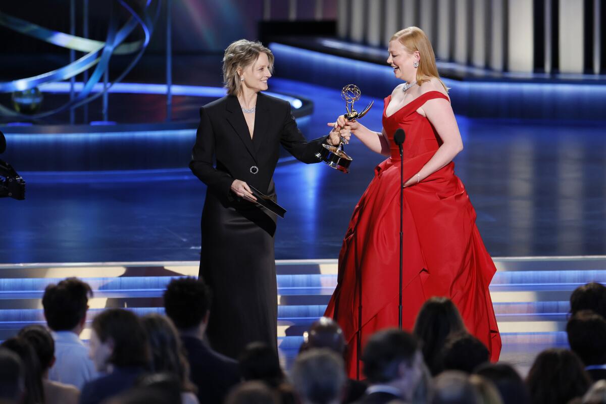 Jodie Foster, left, gives Sarah Snook an Emmys statuette.