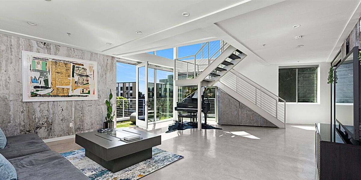 One of nine units in a modern complex, the glass-and-concrete condo holds three bedrooms in roughly 2,000 square feet.