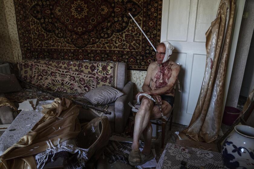 66-year-old Volodymyr, injured from a strike, sits on a chair in his damaged apartment, in Kramatorsk, Donetsk region, eastern Ukraine, Thursday, July 7, 2022. (AP Photo/Nariman El-Mofty)