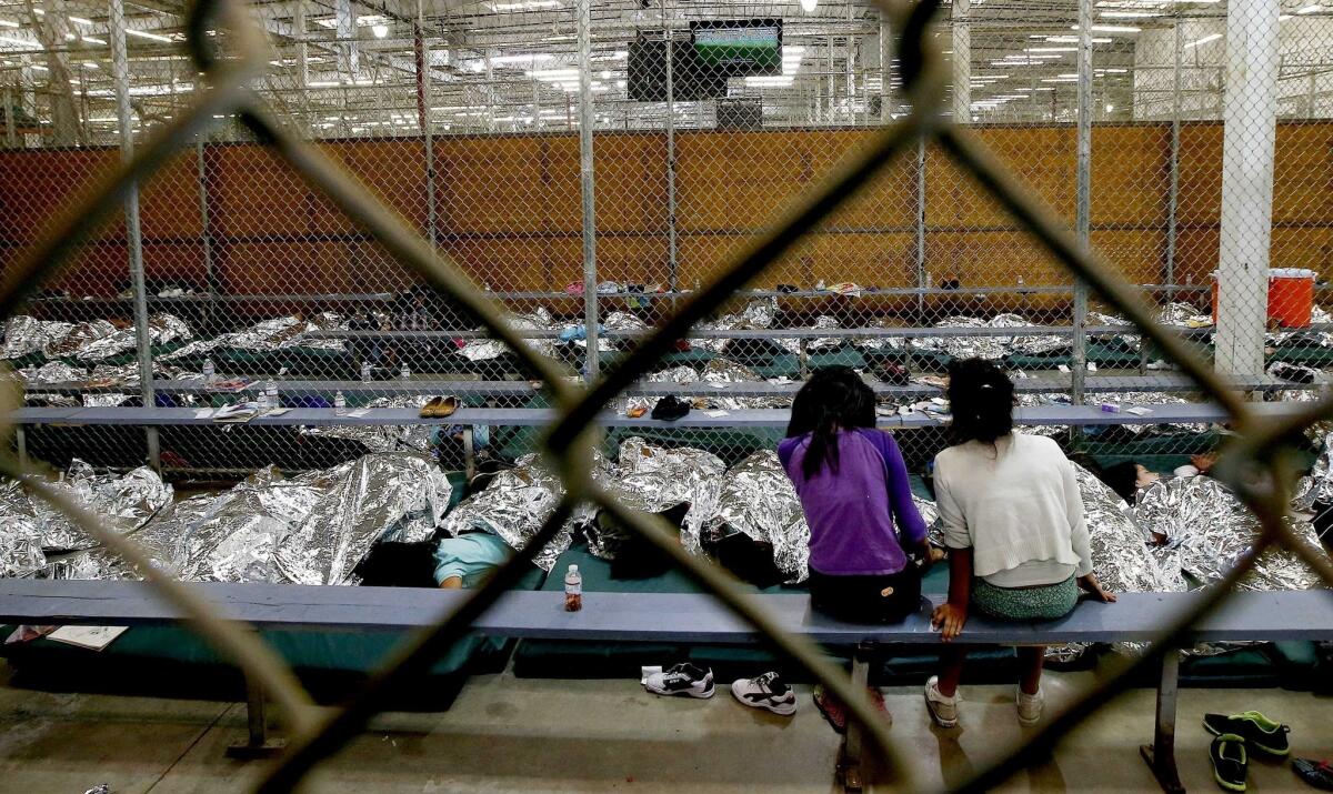 Foto del 18 de junio del 2014 en la que dos niñas miran un partido de fútbol en un centro de detención del servicio de inmigración en Nogales, Arizona. Detractores de Donald Trump usaron fotos del 2014, tomadas bajo el gobierno de Barack Obama, para denunciar las políticas de Trump hacia la inmigración ilegal.