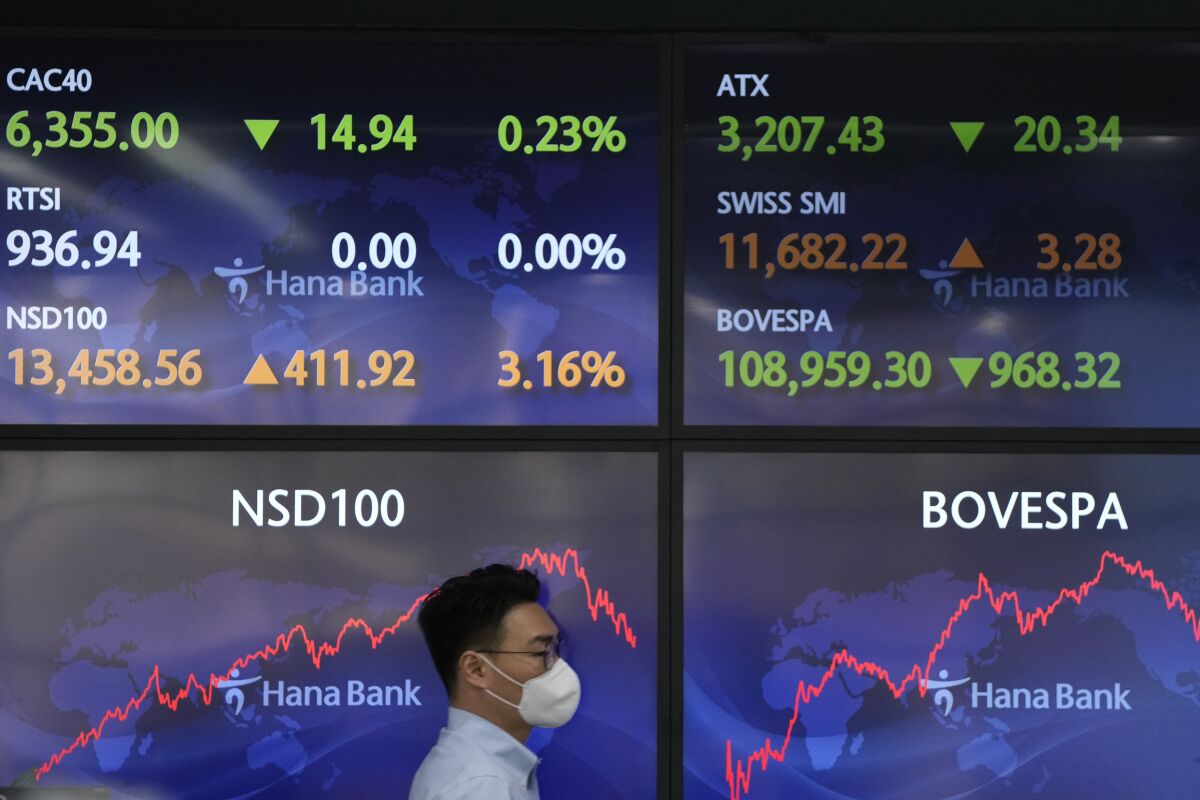 A currency trader walks near the screens at a foreign exchange dealing room in Seoul, South Korea, Wednesday, March 16, 2022. Asian shares rose Wednesday as investors awaited a widely anticipated decision by the U.S. Federal Reserve on interest rate policy. (AP Photo/Lee Jin-man)