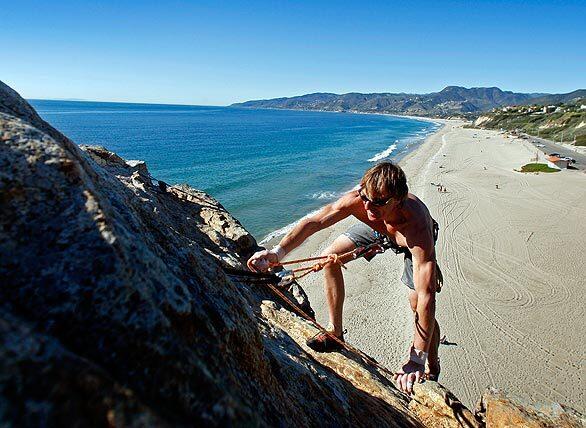Greg Domanski, 45, of Santa Monica climbs down Point Dume in Malibu. Domanski, who escaped communism in Poland in 1985, said he has been enjoying his freedom in America since 1989 and climbs Point Dume every week.