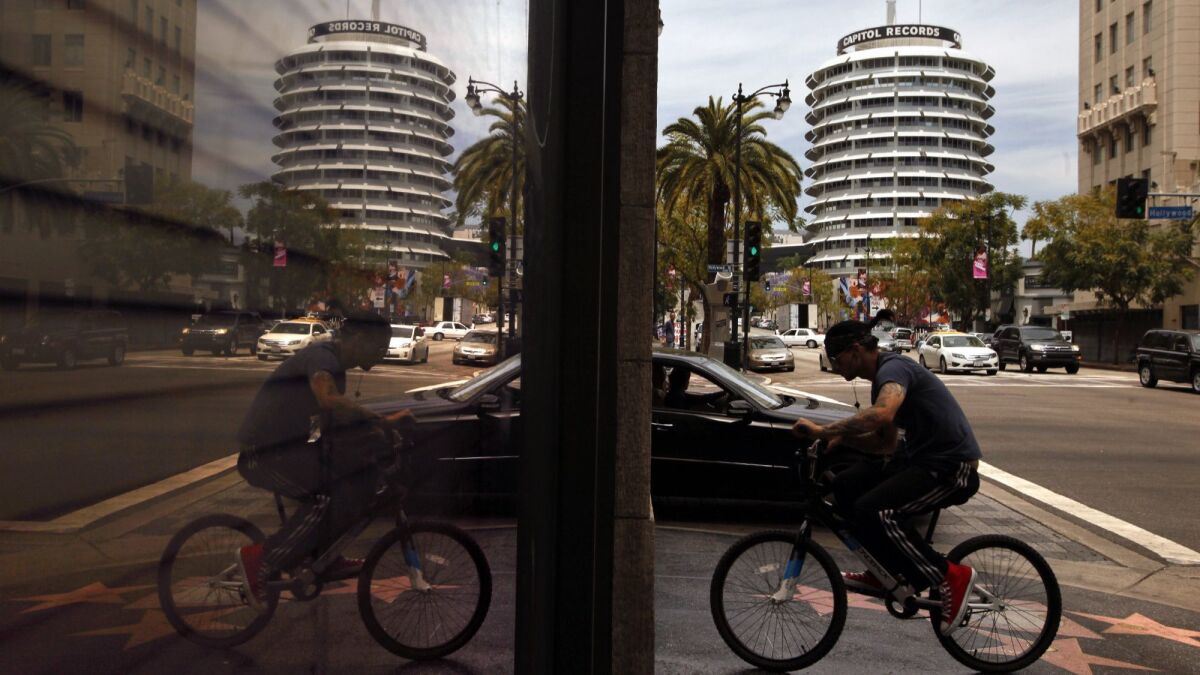 A bicyclist rides in Hollywood with the Capitol Records building in the background near where the Hollywood Center project is proposed.
