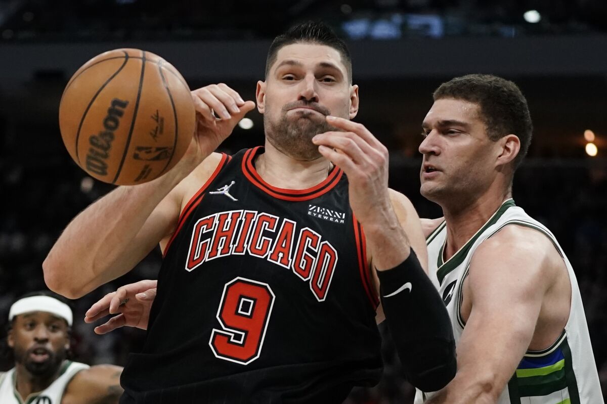 Milwaukee Bucks' Brook Lopez knocks the ball from Chicago Bulls' Nikola Vucevic during the second half of Game 1 of their first round NBA playoff basketball game Sunday, April 17, 2022, in Milwaukee. The Bucks won 93-86 to take a 1-0 lead in the series. (AP Photo/Morry Gash)