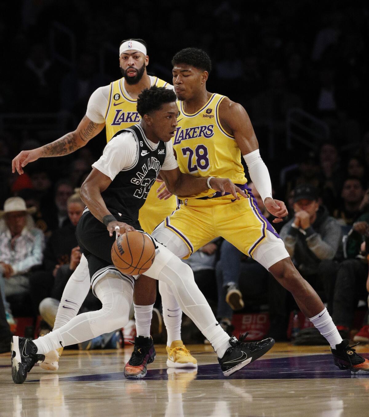 Lakers' Rui Hachimura stands his ground defensively as San Antonio Spurs forward Stanley Johnson drives to the basket.