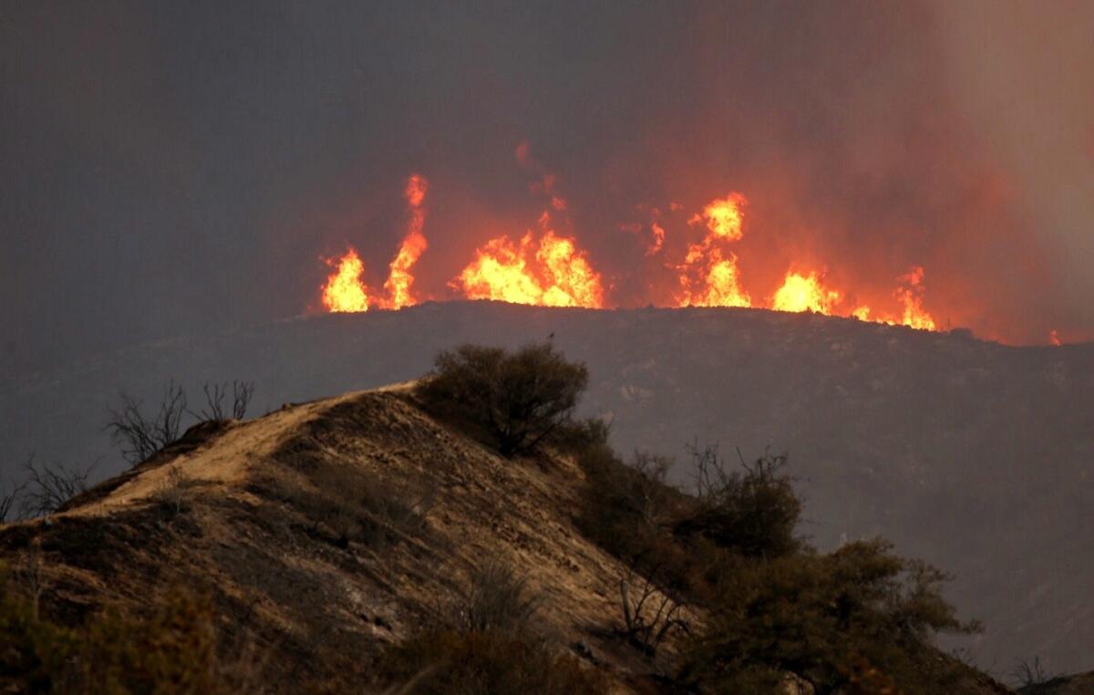 Flames rear up in the mountains near Acton as nearly 3,000 firefighters converge on the Sand fire.
