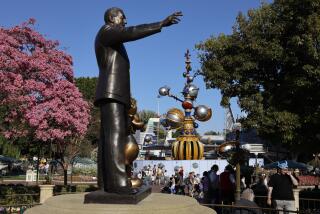 Anaheim, CA - March 11: Partners, foreground, a 1993 copper statue by Blaine Gibson depicting Walt Disney holding the hand of the most popular character he created, Mickey Mouse and Tomorrowland in the background at Disneyland Monday, March 11, 2024. (Allen J. Schaben / Los Angeles Times)