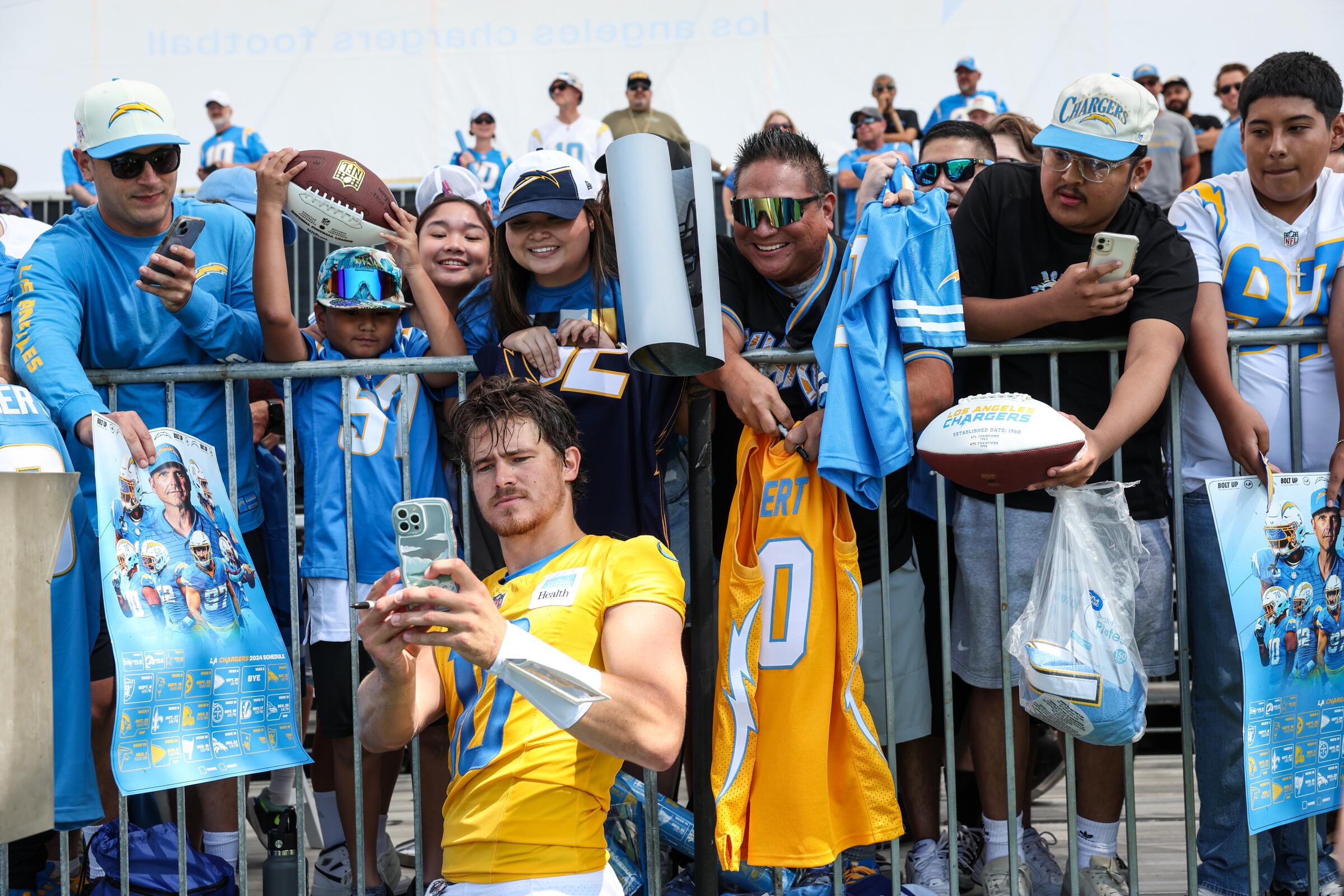 Chargers quarterback Justin Herbert takes a selfie in front of enthusiastic Chargers fans.